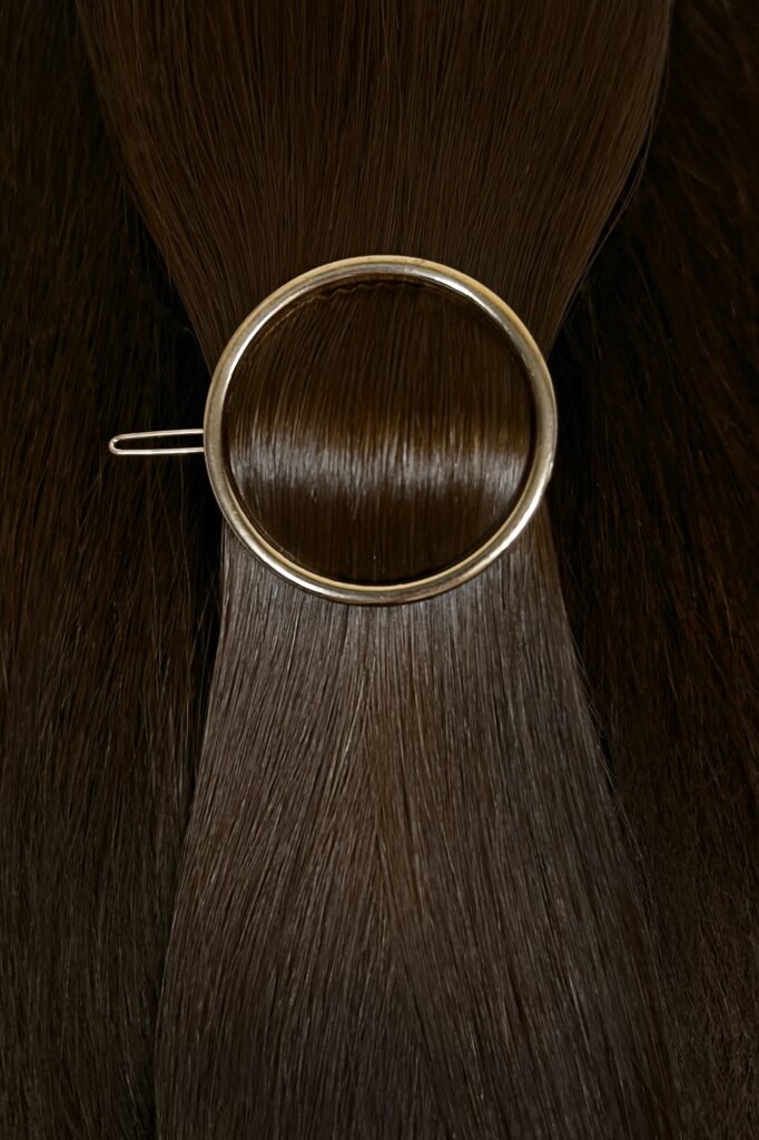 A strand of natural hair extensions with a hairpin.